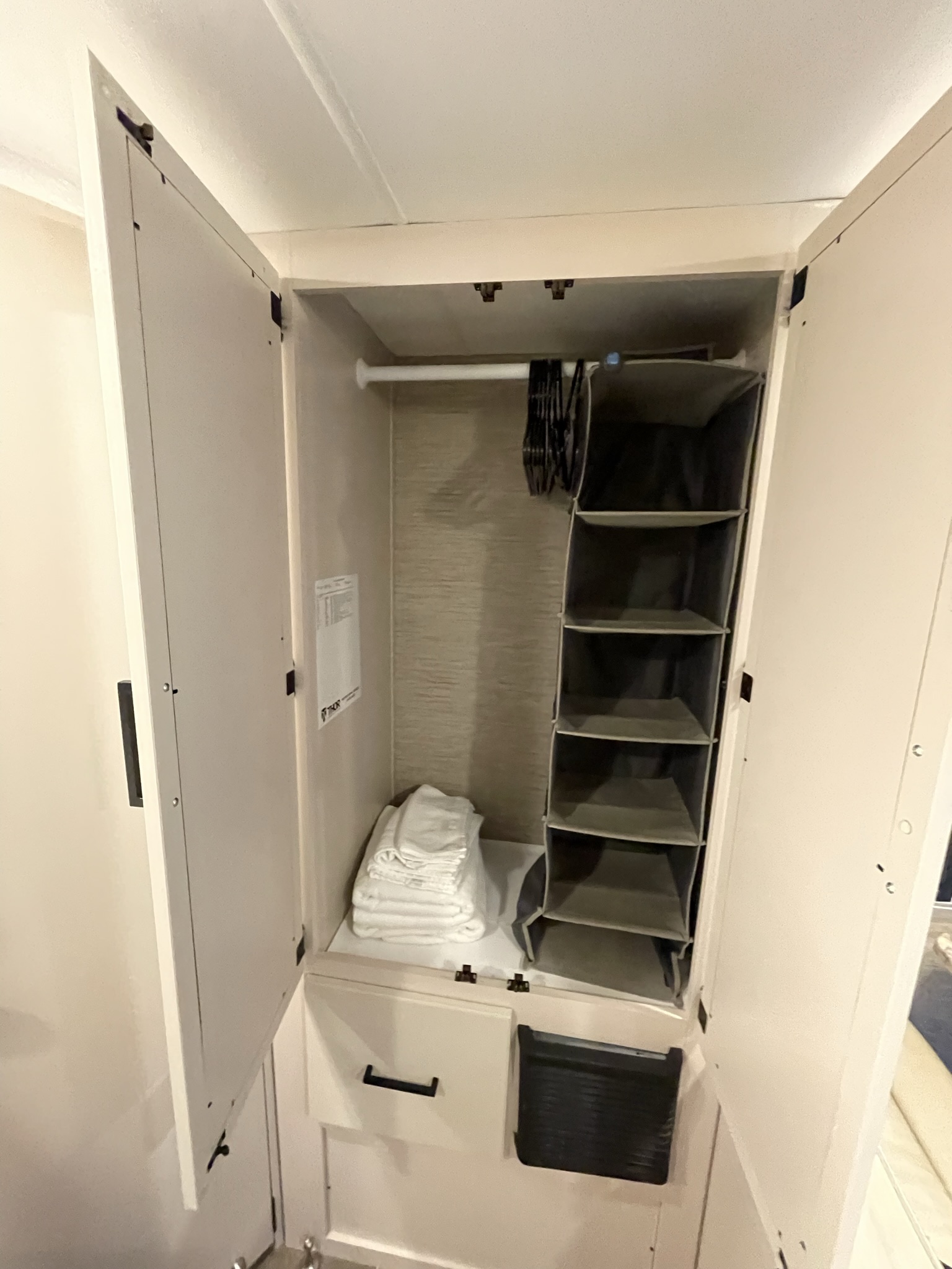 Closet storage inside 2022 Thor Chateau Roadrunner RV with hanging rod, shelves, and folded towels.
