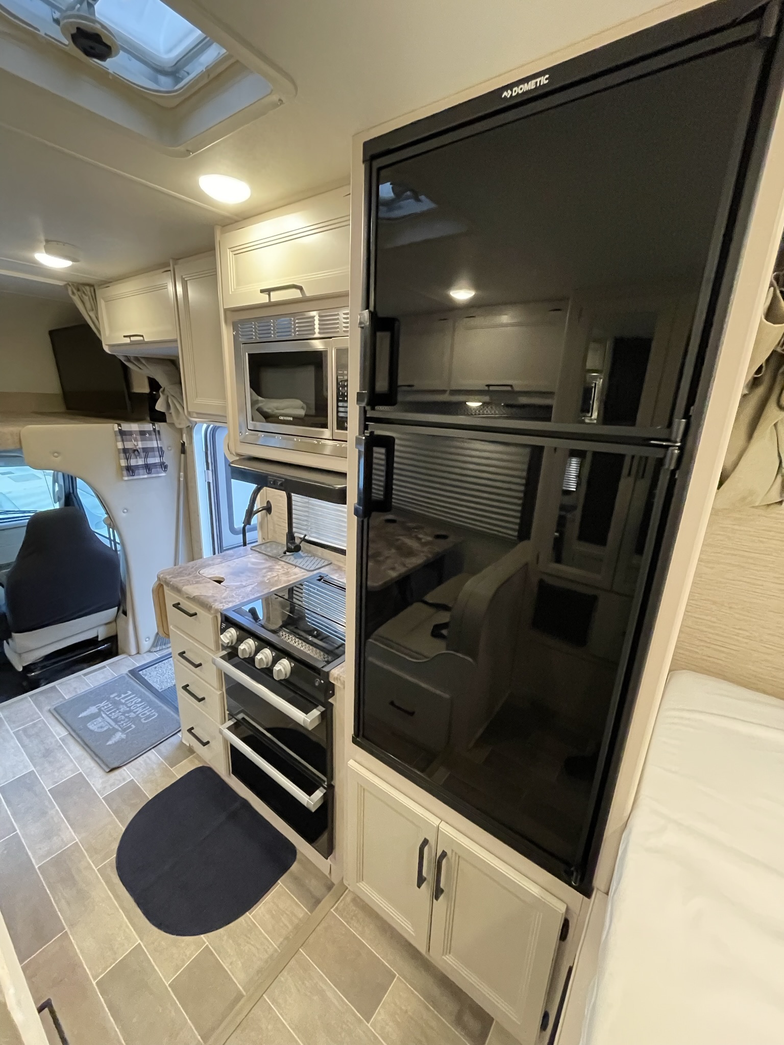 Kitchen in 2022 Thor Chateau Roadrunner with stove, oven, microwave, and large refrigerator.