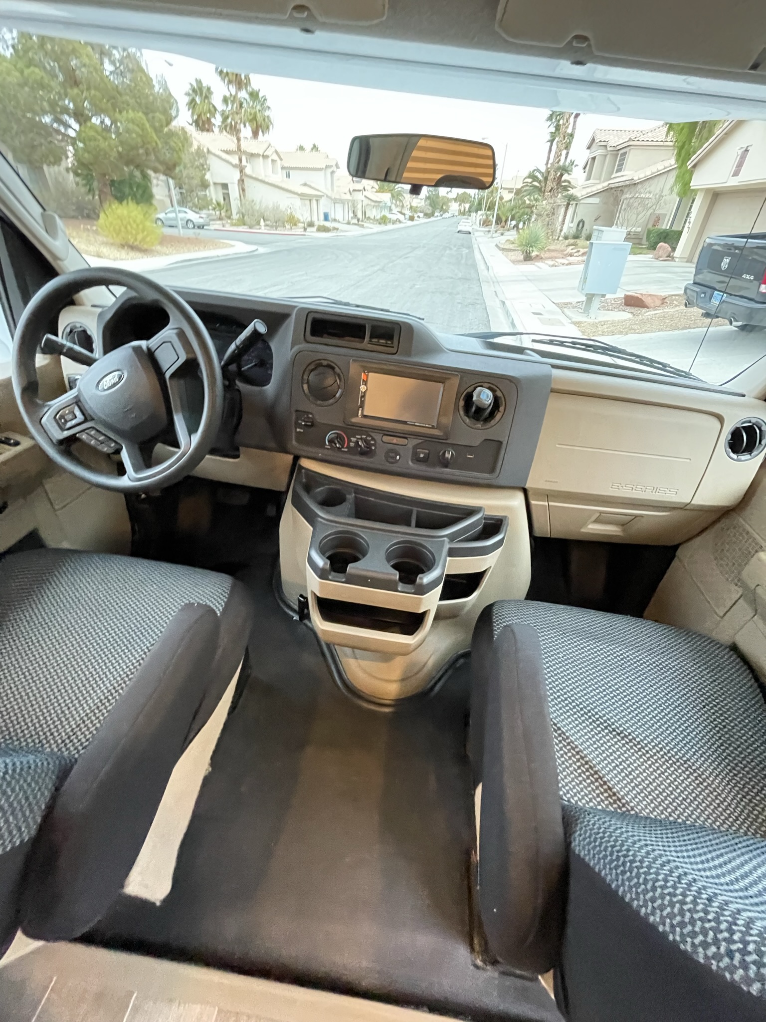 Driver’s cabin of 2022 Thor Chateau Roadrunner RV with steering wheel, dashboard, and cupholders.