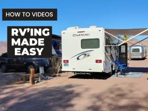 A white RV parked at at campsite with hookups